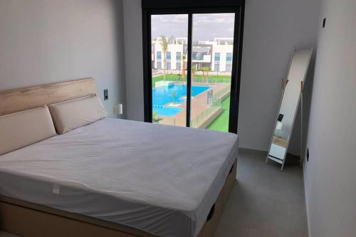 una camera con letto e vista sulla piscina di Oasis Beach Dream Holiday a Guardamar del Segura