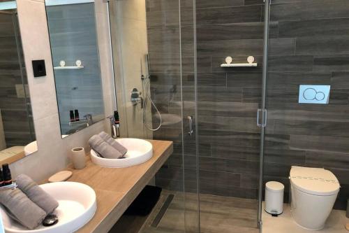 a bathroom with two sinks and a glass shower at Oasis Beach Dream Holiday in Guardamar del Segura