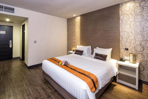 1 dormitorio con 1 cama blanca grande en una habitación en Oria Hotel Jakarta, en Yakarta