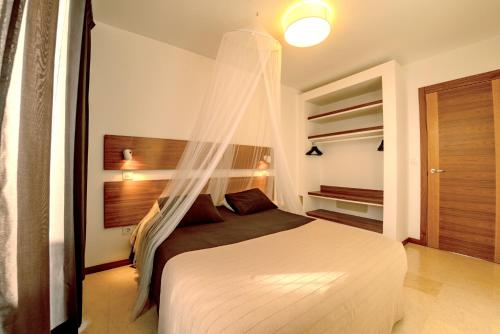 a bedroom with a bed with a mosquito net at Casa Chani with heated pool in El Roque in Cotillo