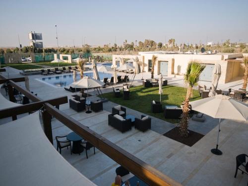 an overhead view of a resort with a pool and tables and chairs at Amman Airport Hotel in Al Qasţal