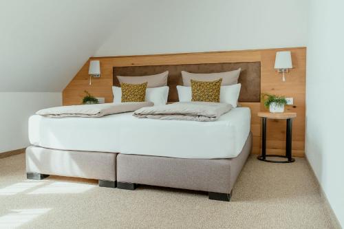 a bedroom with a large white bed with a wooden headboard at Kondrauer Hof in Waldsassen