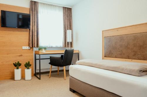 a bedroom with a bed and a desk with a chair at Kondrauer Hof in Waldsassen