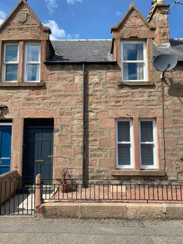 an old stone house with a blue door and windows at No. 20 in Inverness