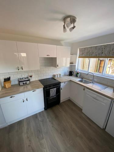 a kitchen with white cabinets and a black stove at No. 20 in Inverness