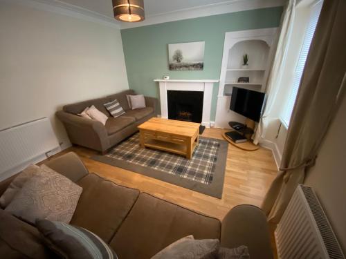 ein Wohnzimmer mit Sofa und TV in der Unterkunft No. 20 in Inverness