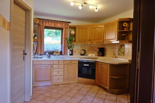 eine Küche mit Holzschränken und einem Fenster in der Unterkunft Elbblick in Prossen