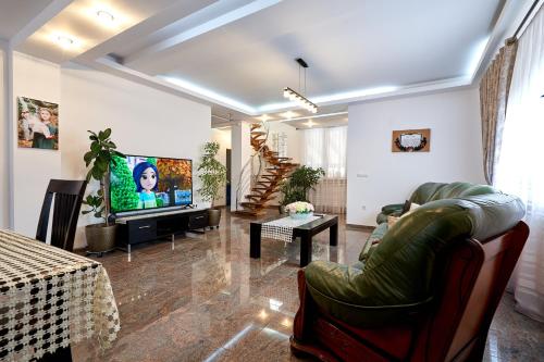 a living room with a couch and a tv at Casa cu Flori Moisei in Moisei