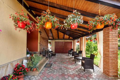 a patio with tables and chairs and potted plants at Casa cu Flori Moisei in Moisei