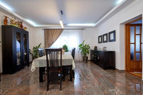 a dining room with a table and chairs and a window at Casa cu Flori Moisei in Moisei