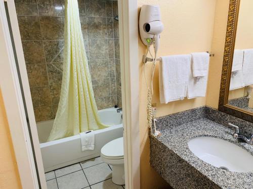y baño con lavabo, aseo y ducha. en Budget Inn Jonesboro en Jonesboro