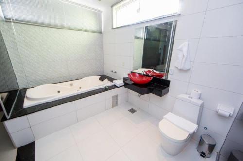 a bathroom with a tub and a toilet and a sink at PUMMA BUDGET HOTEL in Canaã dos Carajás