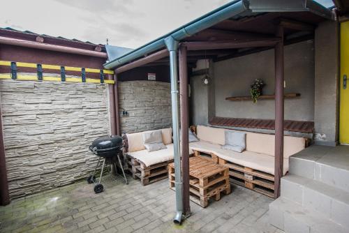 a covered patio with two benches and a grill at Malovaný dvoreček in Dolní Dunajovice