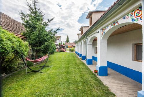 a chair sitting on the grass next to a building at Malovaný dvoreček in Dolní Dunajovice