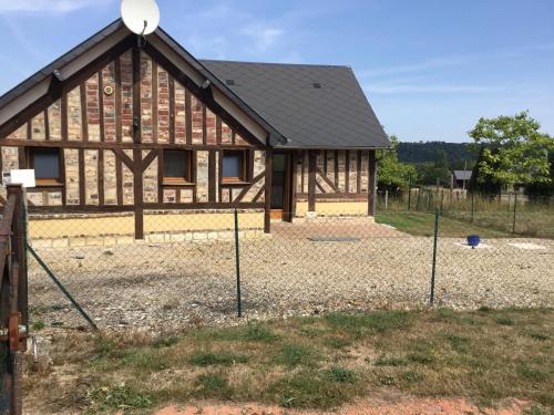 a barn with a fence in front of it at GITE LE MONTENEY in Pont-Audemer