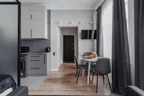 uma cozinha e sala de jantar com mesa e cadeiras em City Centre Silver Apartment em Odessa