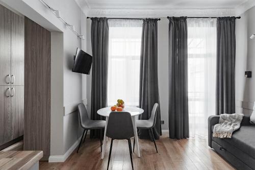 sala de estar con mesa y sillas en una habitación en City Centre Silver Apartment, en Odessa