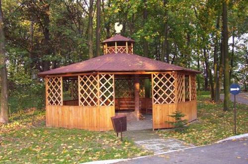 a wooden gazebo with a tower in a park at Willa Park in Ostrowiec Świętokrzyski