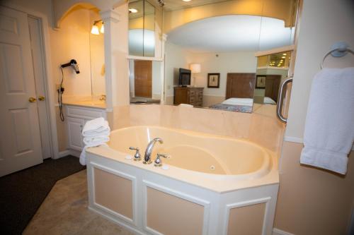 a bathroom with a tub and a large mirror at InnSeason Resorts The Falls at Ogunquit in Ogunquit