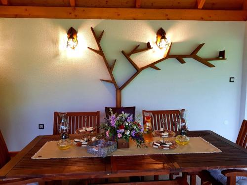 a dining room table with two chairs and a table with flowers at Chata VČELÁRIK in Nová Baňa