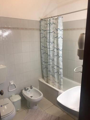a bathroom with a toilet sink and a shower curtain at Dom Quixote apartamentos turísticos in Praia de Mira