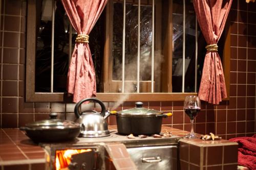 una cocina con fogones con una olla y una copa de vino en Venha curtir suas férias, com privacidade em Laguna-SC, en Laguna