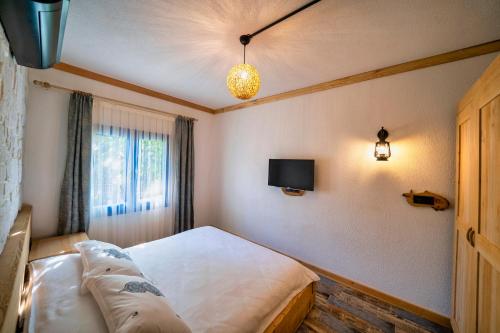 a bedroom with a bed and a tv on the wall at Only Blue Villa in Göcek