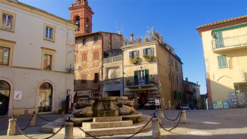 a group of buildings with a fountain in the middle of a street at Residence Al Lago in Castiglione del Lago