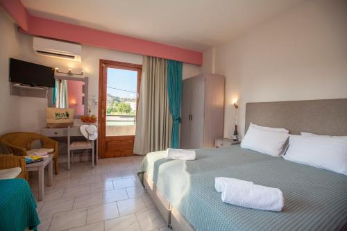 a hotel room with a large bed and a desk at John Mary in Faliraki