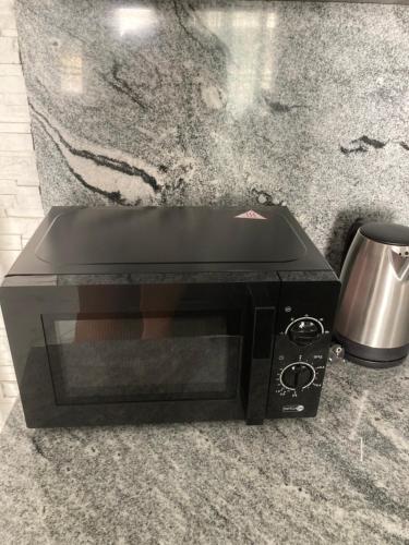 a black toaster oven sitting on top of a counter at Swiss Luxury Apartment in Mosonmagyaróvár