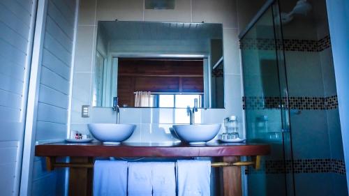 a bathroom with two sinks and a glass shower at White Wind Resort in Itarema