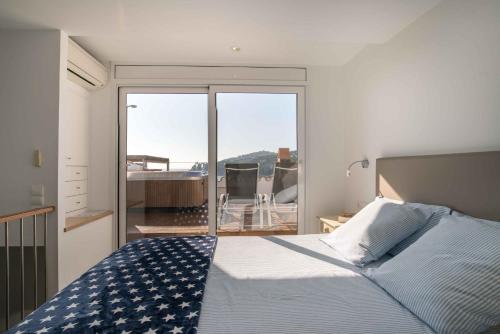 1 dormitorio con cama y vistas a un balcón en Penthouse Cortey, en Calella de Palafrugell