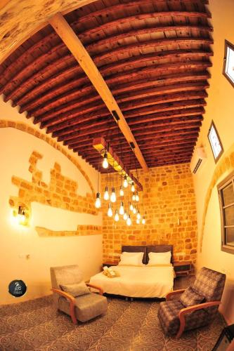a bedroom with a bed and a brick wall at Salah Aldin House in Acre