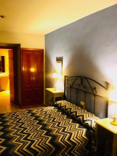 a bedroom with a black and white bed with a blue wall at Hostal León in Trujillo