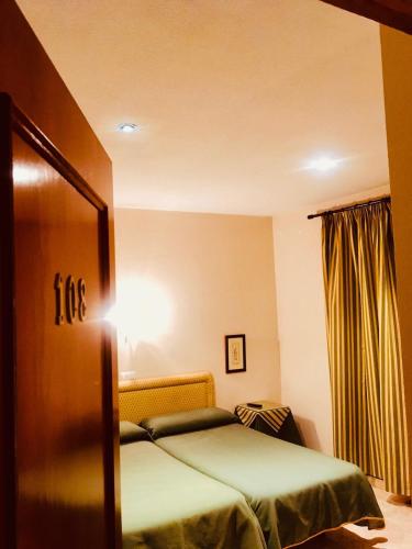 a hotel room with a bed and a mirror at Hostal León in Trujillo