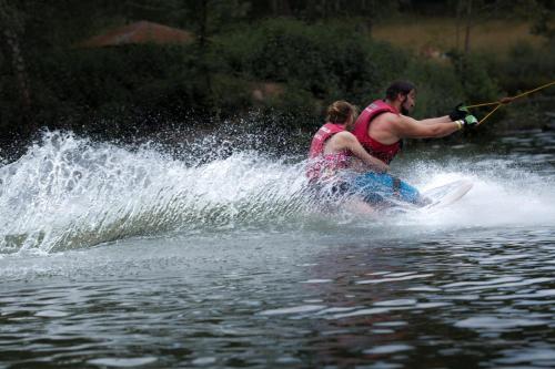 a man and a woman on a board in the water at Ferienhaus "Schmetterling" am See im Bergland in Kirchheim
