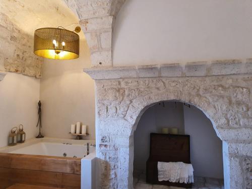 a bathroom with a bath tub and a fireplace at Caterina's Suites & Apartament in Ostuni
