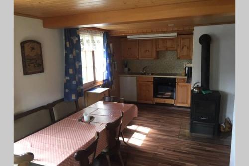 uma sala de estar com uma mesa e uma cozinha em Idyllisches Chalet inmitten der Walliser Bergwelt em Riederalp