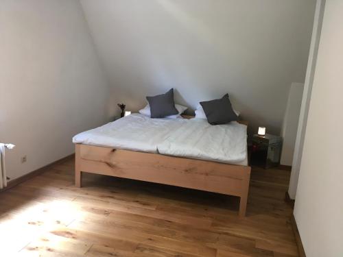 a bed with two pillows on it in a room at Haus Tersteegen in Oberbrombach