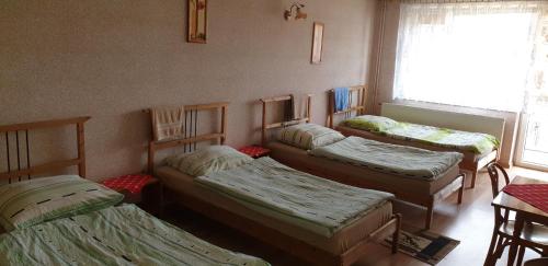 3 camas en una habitación con ventana en Wynajem Pokoi dla Firm en Libiąż