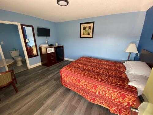 a hotel room with a bed and a bathroom at Red Carpet Inn & Suites Wrightstown in Wrightstown