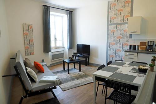 a living room with a table and a dining room at L'appartement 62 in Le Lonzac