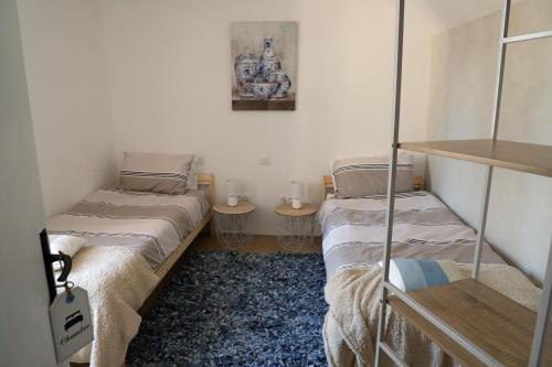 duas camas num pequeno quarto com duas mesas em L'appartement 62 em Le Lonzac