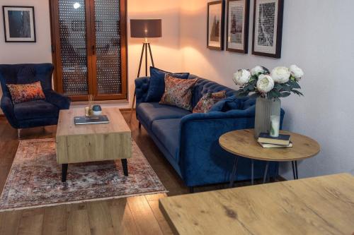 a living room with a blue couch and a table at Guesthouse Check In in Stolac