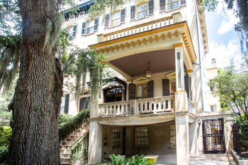 an old house with a balcony and a tree at The Gastonian, Historic Inns of Savannah Collection in Savannah