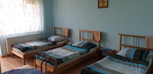 a room with three beds and a window at Wynajem Pokoi dla Firm in Libiąż