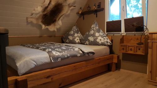 1 dormitorio con cama de madera y almohadas en Manu's Ferienwohnung, en Schluchsee