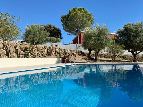 a blue swimming pool with trees in the background at Casal da Rita Campestre in Vaqueiros