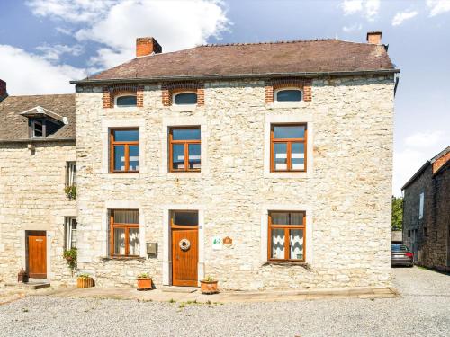 ein altes Steinhaus mit braunen Türen und Fenstern in der Unterkunft Plush Holiday Home in Matagne La Petite with Private Garden in Matagne-la-Petite