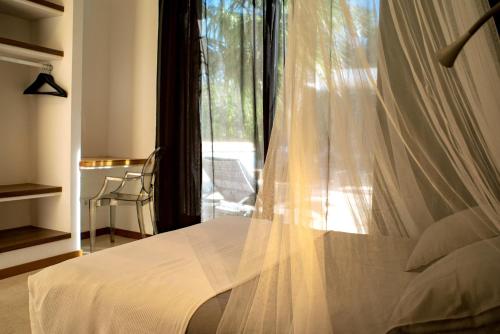 1 dormitorio con 1 cama blanca y ventana en Casa Paloma with heated pool in El Roque, en Cotillo